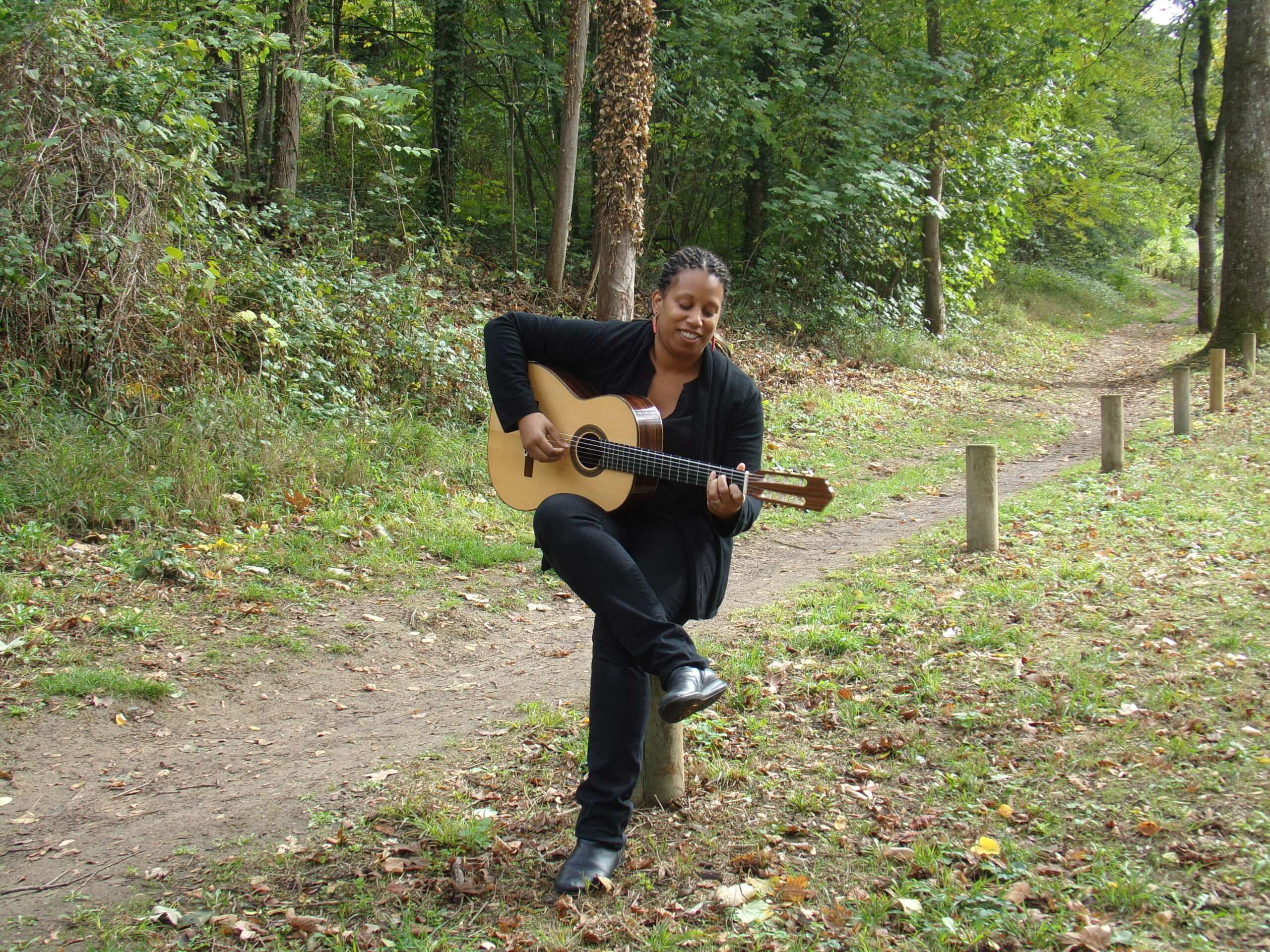 Elodie Redon, maître du stage guitare 2025 des Rencontres Voix & Musiques, jouant de la guitare dans une forêt.